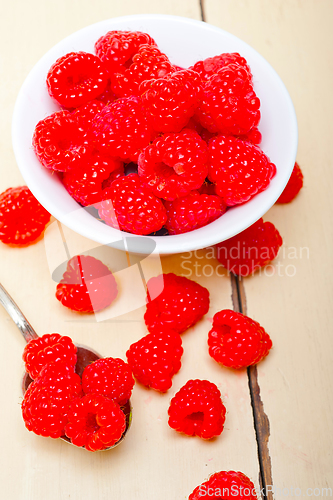 Image of bunch of fresh raspberry on a bowl and white table