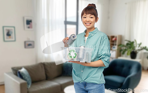 Image of smiling young asian woman sorting metallic waste