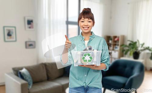 Image of smiling young asian woman sorting metallic waste