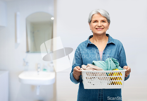 Image of smiling senior woman with laundry basket