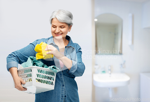 Image of smiling senior woman with laundry basket