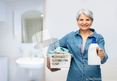 Image of smiling senior woman with laundry basket