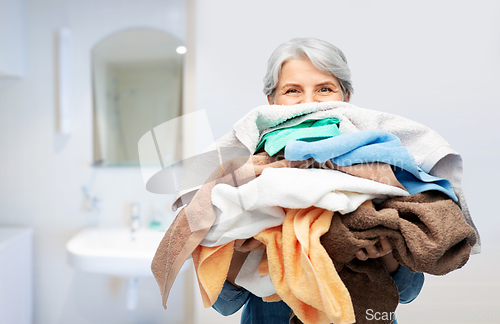 Image of senior woman with heap of bath towels