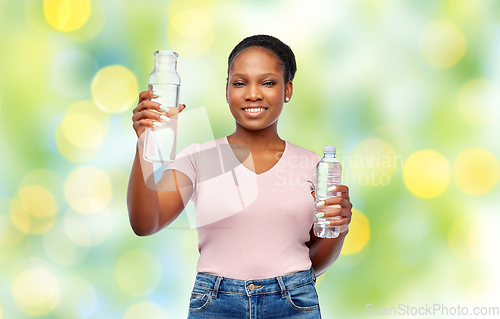 Image of happy woman with plastic and glass bottle of water