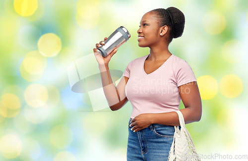 Image of woman with tumbler and food in string bag