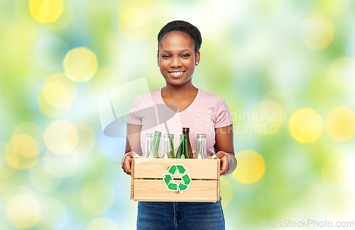 Image of happy african american woman sorting glass waste