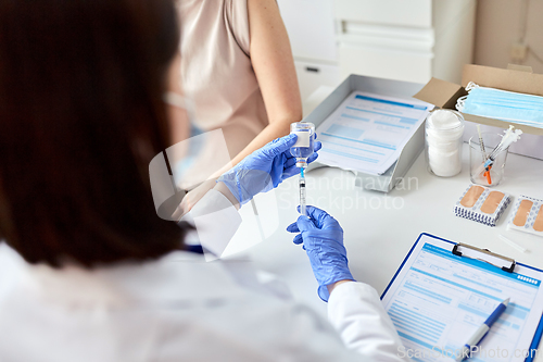 Image of female doctor with syringe vaccinating patient