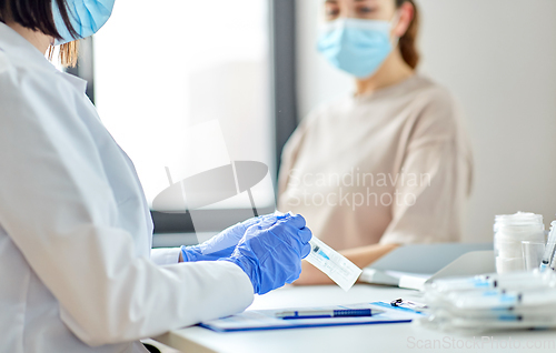 Image of female doctor with syringe and patient at hospital