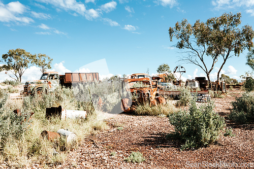 Image of Rusty cars trucks and other items in the desert