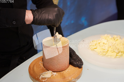 Image of Special cheese knives. The girolle scraper. Making cheese shaving on girolle, closeup