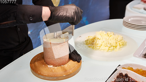 Image of Special cheese knives. The girolle scraper. Making cheese shaving on girolle, closeup