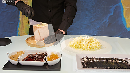 Image of Special cheese knives. The girolle scraper. Making cheese shaving on girolle, closeup