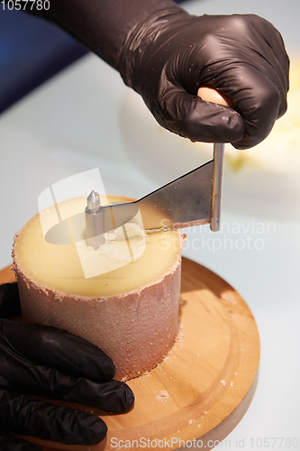Image of Special cheese knives. The girolle scraper. Making cheese shaving on girolle, closeup