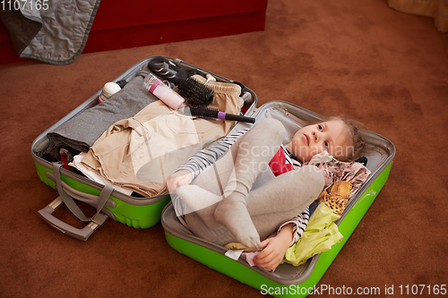 Image of Cute little child inside a big suitcase.