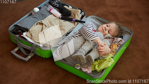 Image of Cute little child inside a big suitcase.