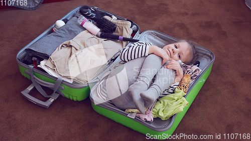 Image of Cute little child inside a big suitcase.