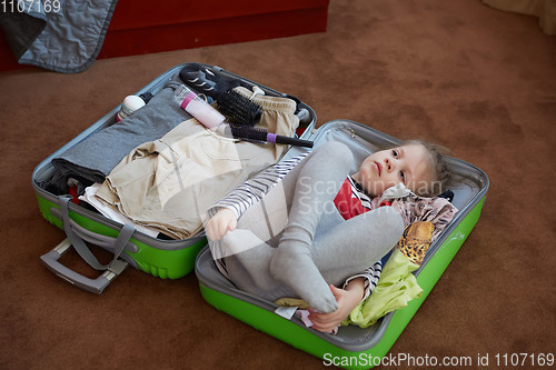 Image of Cute little child inside a big suitcase.