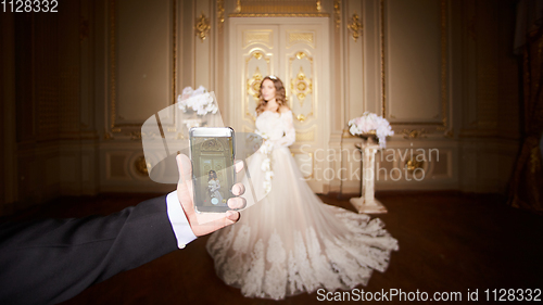 Image of Photographing a bride by the smartphone in luxury interior in the Baroque style.