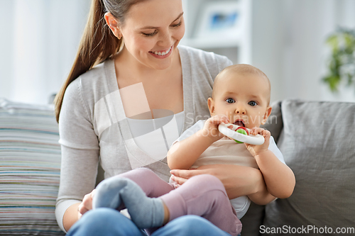 Image of mother and little baby with teething toy at home