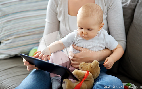 Image of mother and baby girl with tablet pc at home