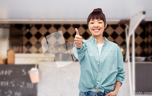 Image of asian woman showing thumbs up over food truck