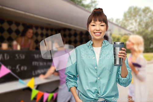 Image of woman with thermo cup or tumbler over food truck