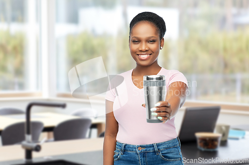 Image of woman with thermo cup or tumbler at home