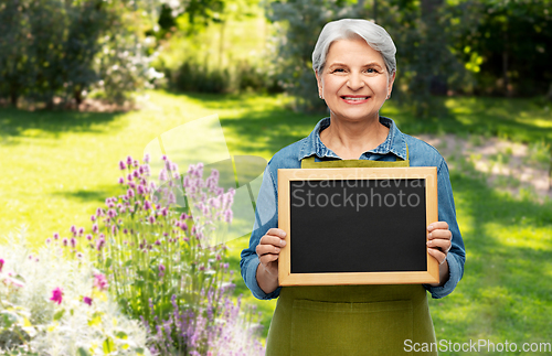 Image of happy senior woman in garden apron with chalkboard