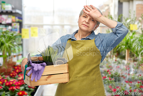 Image of tired senior woman with garden tools in box