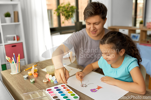 Image of happy father with little daughter drawing at home