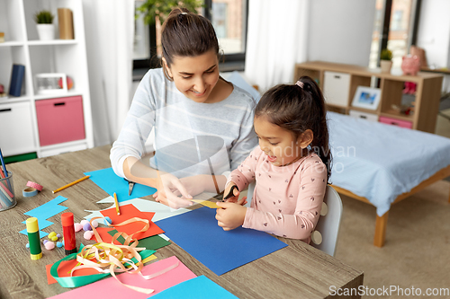 Image of daughter with mother making applique at home