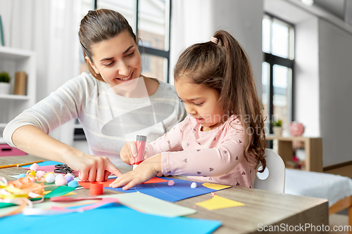 Image of daughter with mother making applique at home