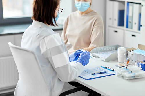 Image of female doctor with syringe and patient at hospital