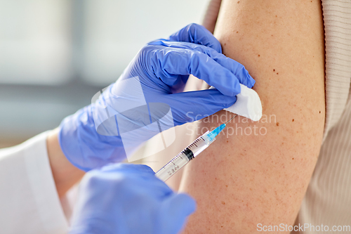 Image of close up of hand with syringe vaccinating patient