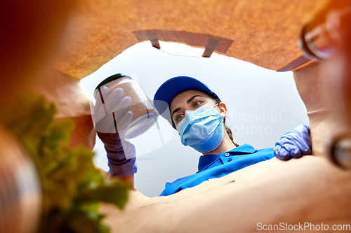 Image of delivery girl in gloves and mask with food in bag