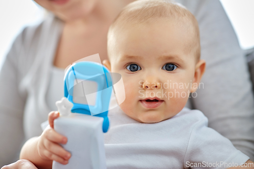 Image of mother with baby playing with toy phone at home