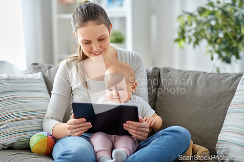 Image of happy mother and baby girl with tablet pc at home