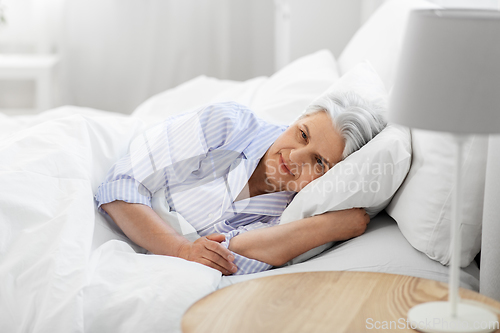 Image of senior woman lying in bed at home bedroom