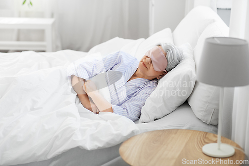 Image of senior woman with eye mask sleeping in bed at home