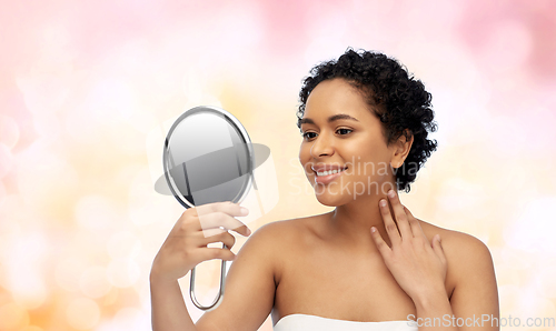 Image of smiling african american woman looking to mirror