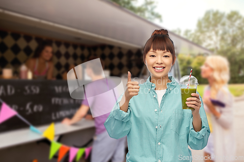 Image of happy asian woman with juice over food truck