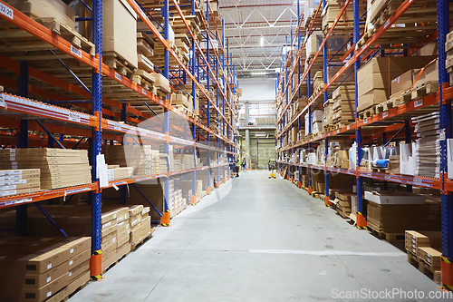 Image of Huge distribution warehouse with high shelves and loaders.