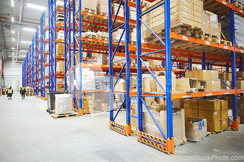 Image of Huge distribution warehouse with high shelves and loaders.