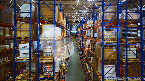 Image of Huge distribution warehouse with high shelves and loaders.