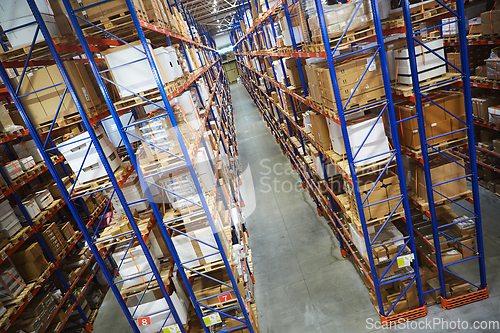 Image of Huge distribution warehouse with high shelves and loaders.