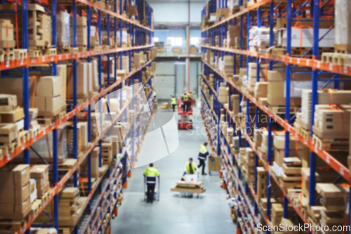 Image of Blur warehouse background. Above view of warehouse workers moving goods and counting stock in aisle between rows of tall shelves full of packed boxes