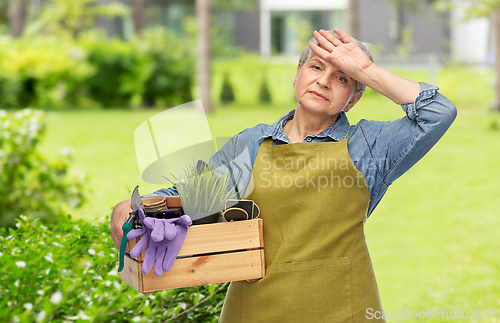 Image of tired senior woman with garden tools in box