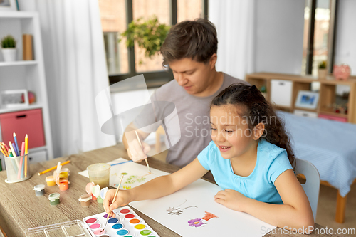 Image of happy father with little daughter drawing at home