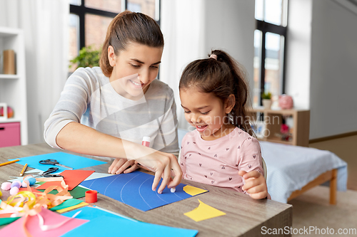 Image of daughter with mother making applique at home