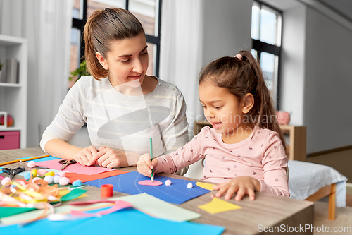 Image of daughter with mother making applique at home